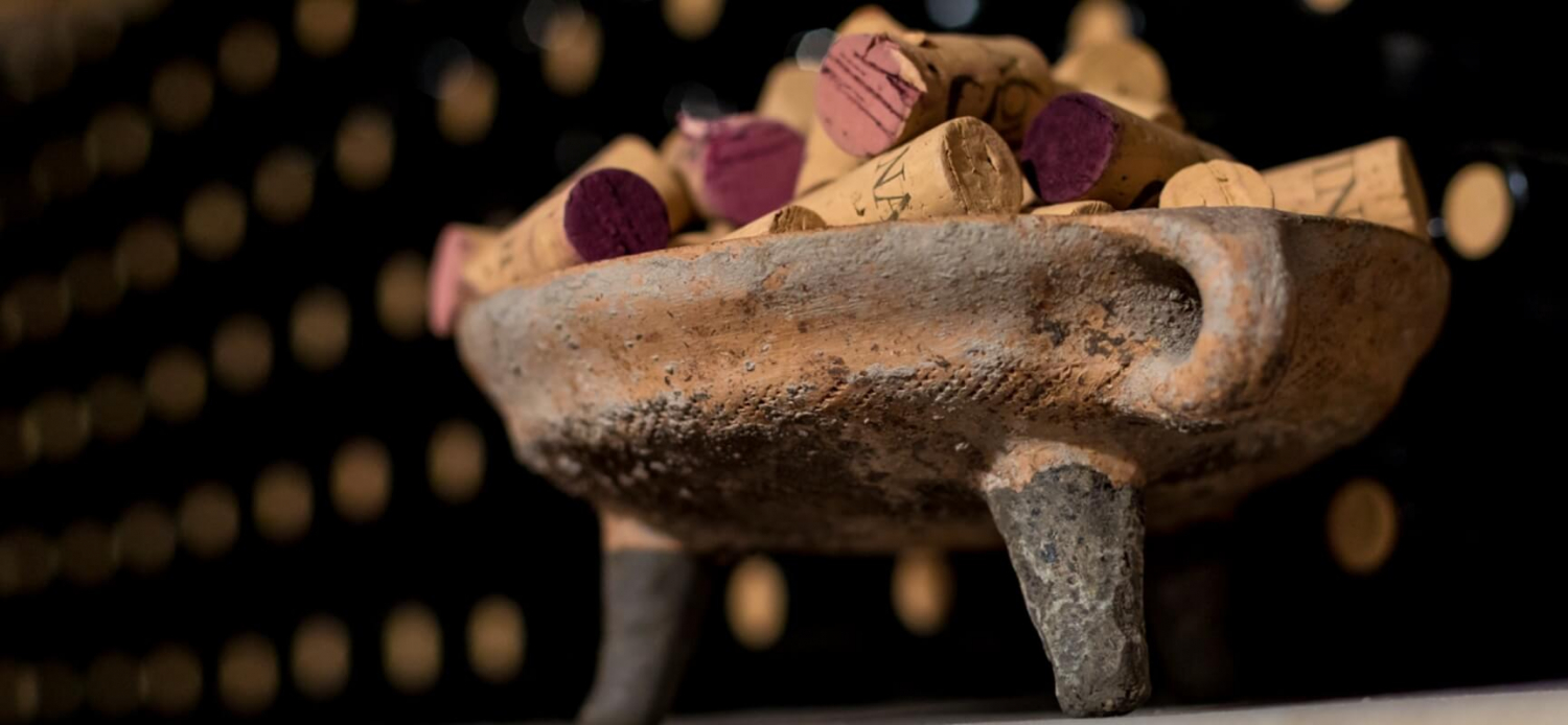 A wooden bowl with used wine corks in it